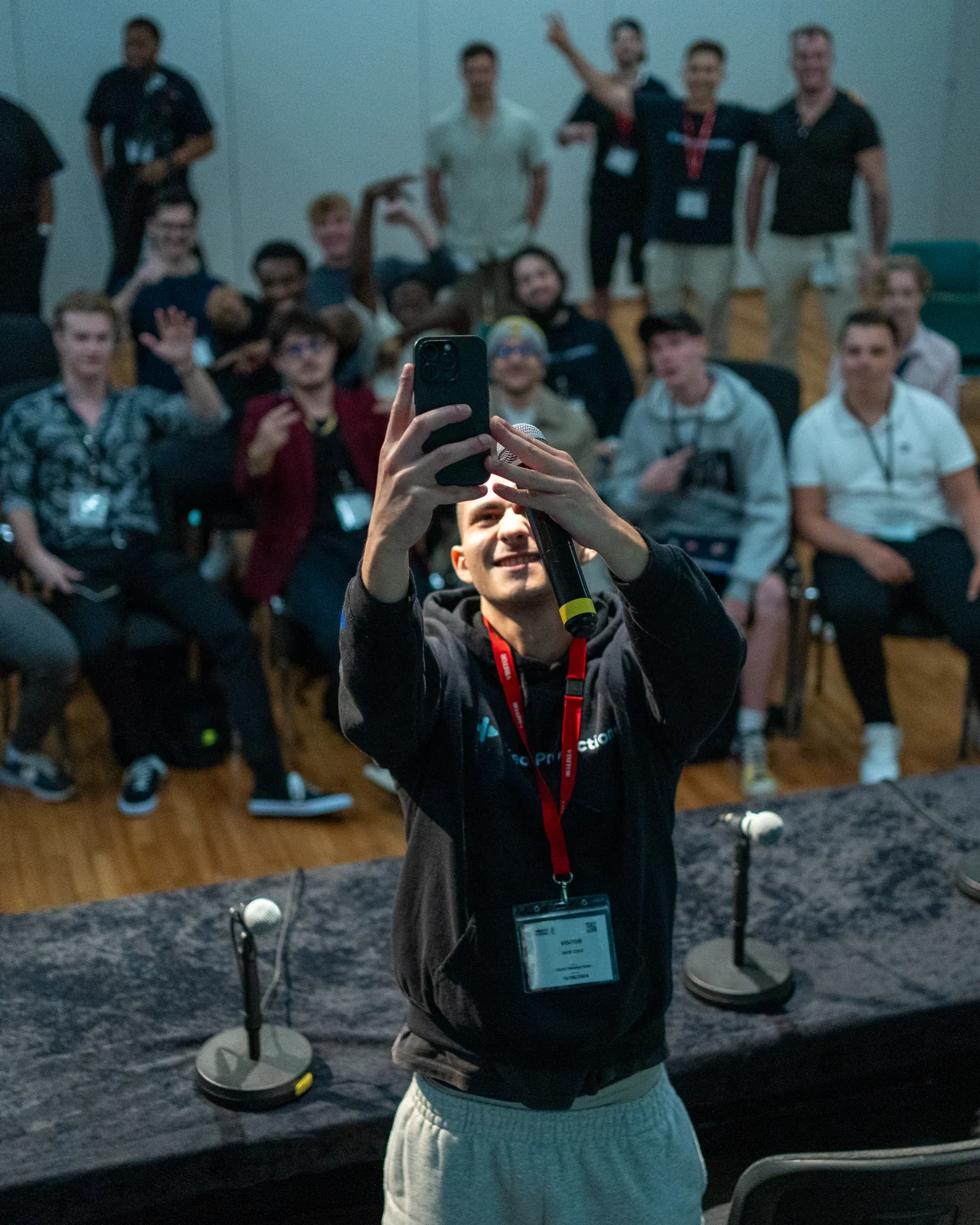 Jack Cole on stage taking a selfie with a room full of editors